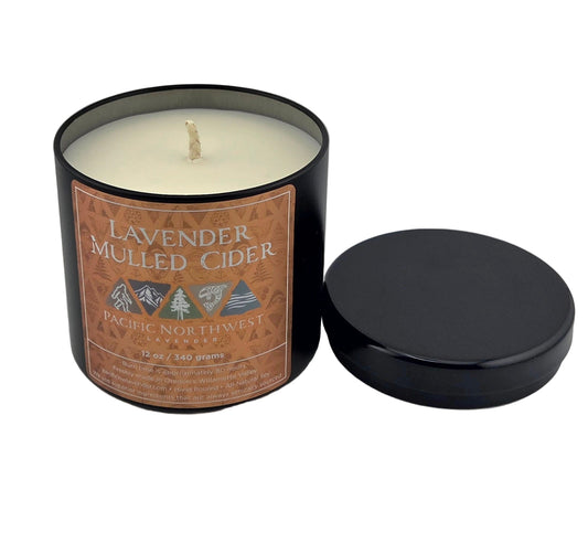 Candle in a black container with a label on a gray background